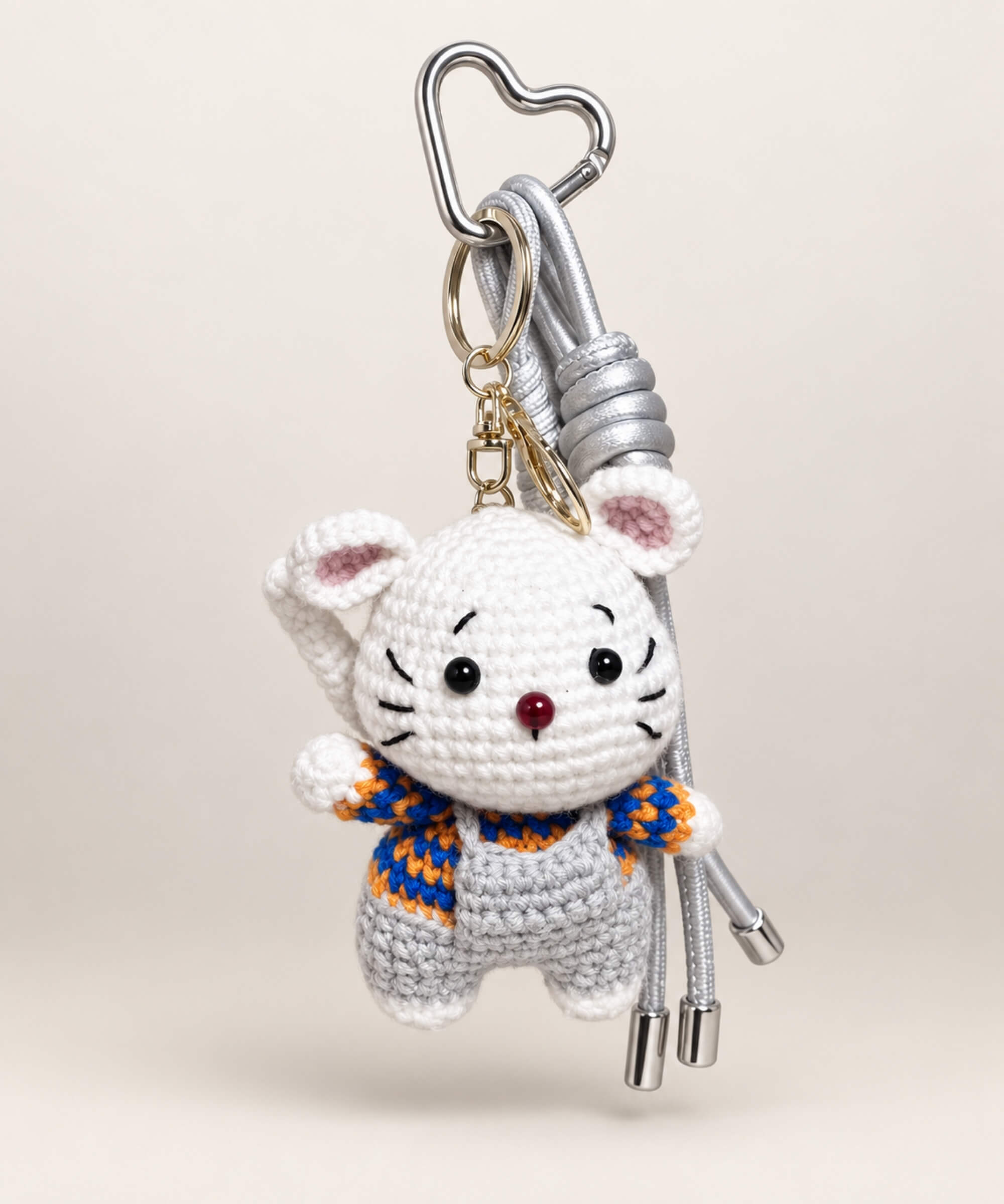 Grey mouse crochet keychain wearing grey overalls with silver hanging cords